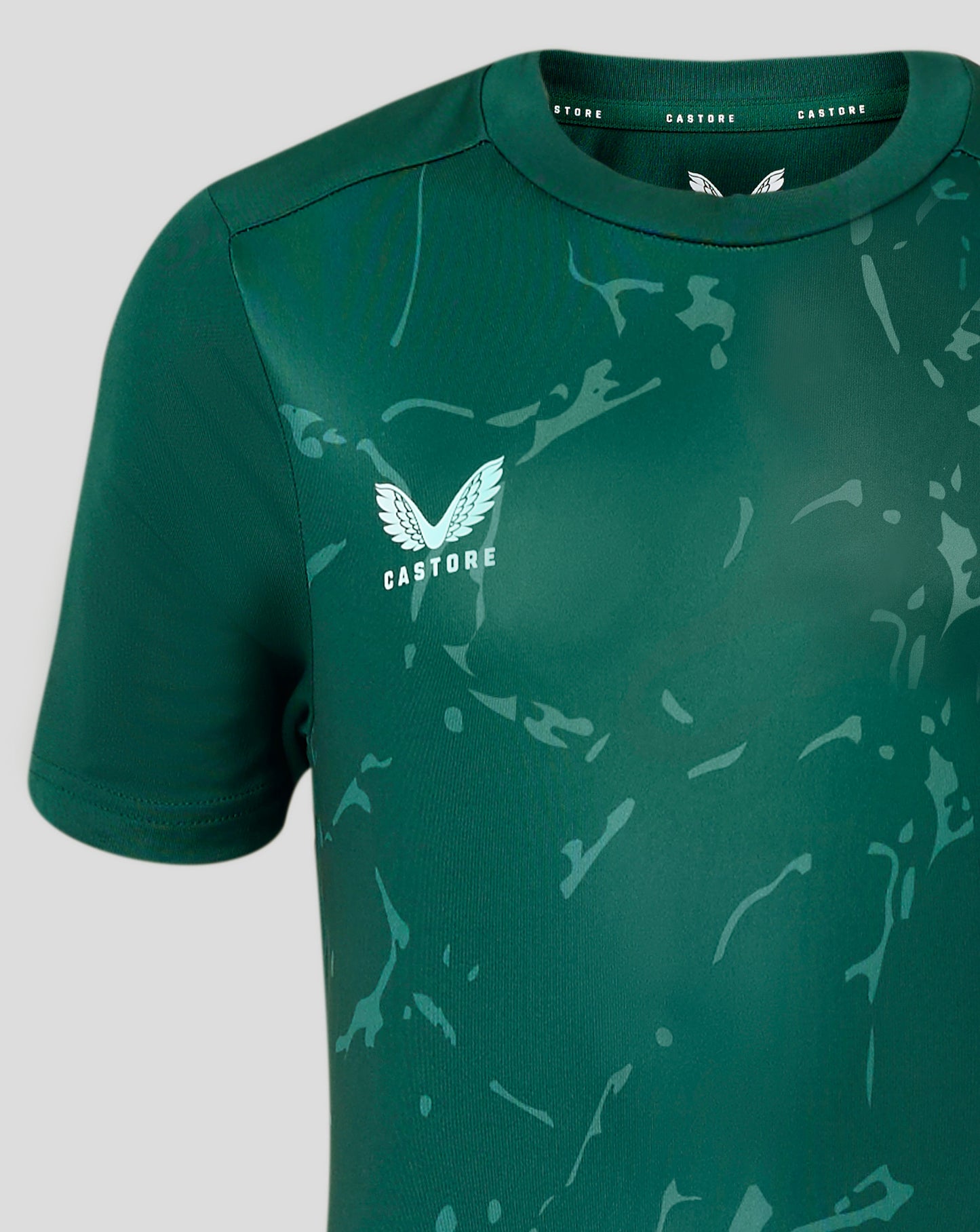 Close up of the collar area on Junior Marble Performance Tee with CASTORE branding on the neck tape and subtle front print