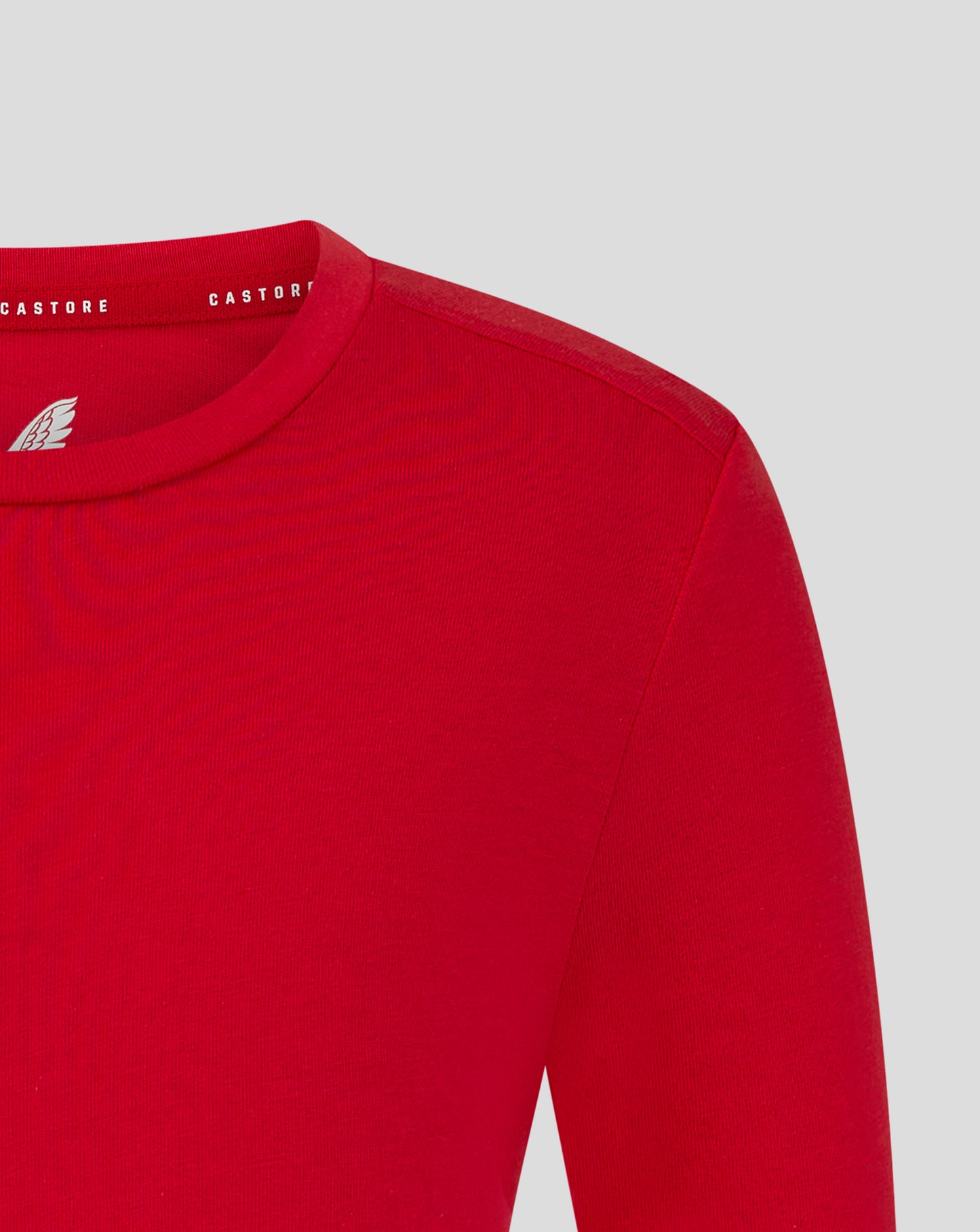Red Junior Cotton Leisure Tee close up shows self fabric crew neck collar and forward shoulder seam with heat sealed Castore logo.