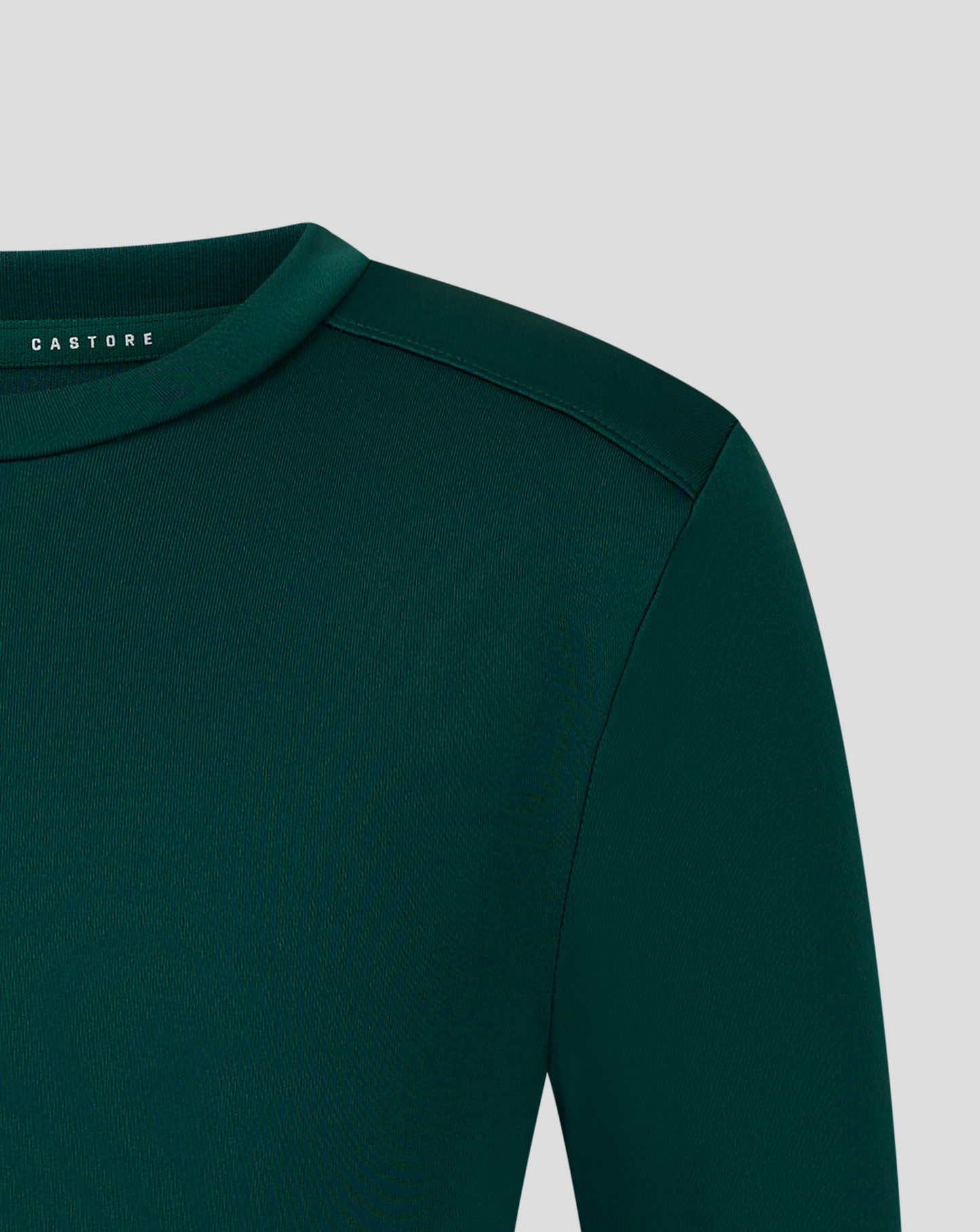 Front view of dark green junior performance tee with white wing crest and Castore text on the chest