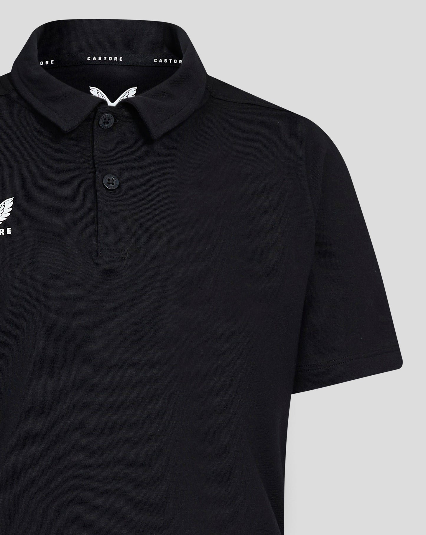 Close up of collar and left chest Castore wing logo on black Junior Cotton Leisure Polo