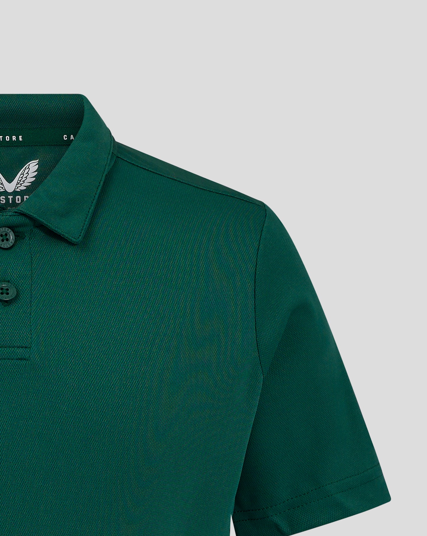 Junior Performance Polo Botanical Garden green close up of collar and shoulder seam with heat sealed Castore logo