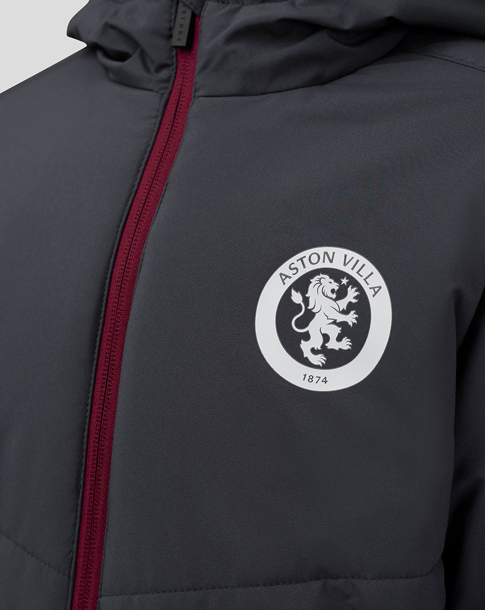 Close up of dark Junior Aston Villa Coaches Long Bench Jacket with a white circular crest and burgundy zipper.