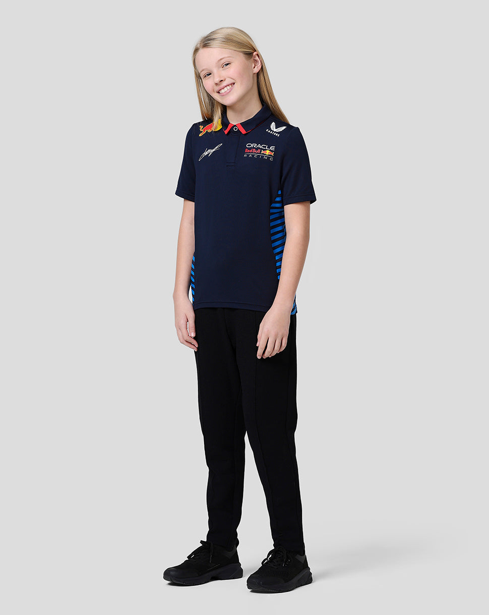 Front view of a smiling girl in a navy Oracle Red Bull Racing junior polo with red collar and team logos
