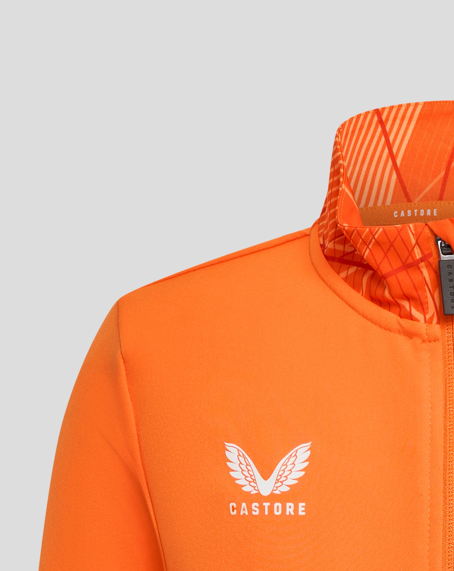Close up of orange Rangers 24/25 Junior League Matchday Anthem Jacket chest area with white winged logo and Castore branding.