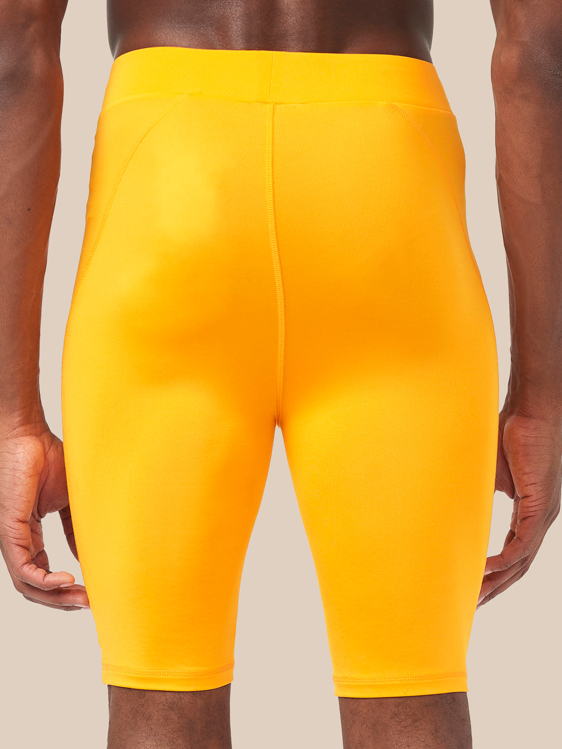 Back view of bright zinnia orange Active Base Layer Shorts on a model
