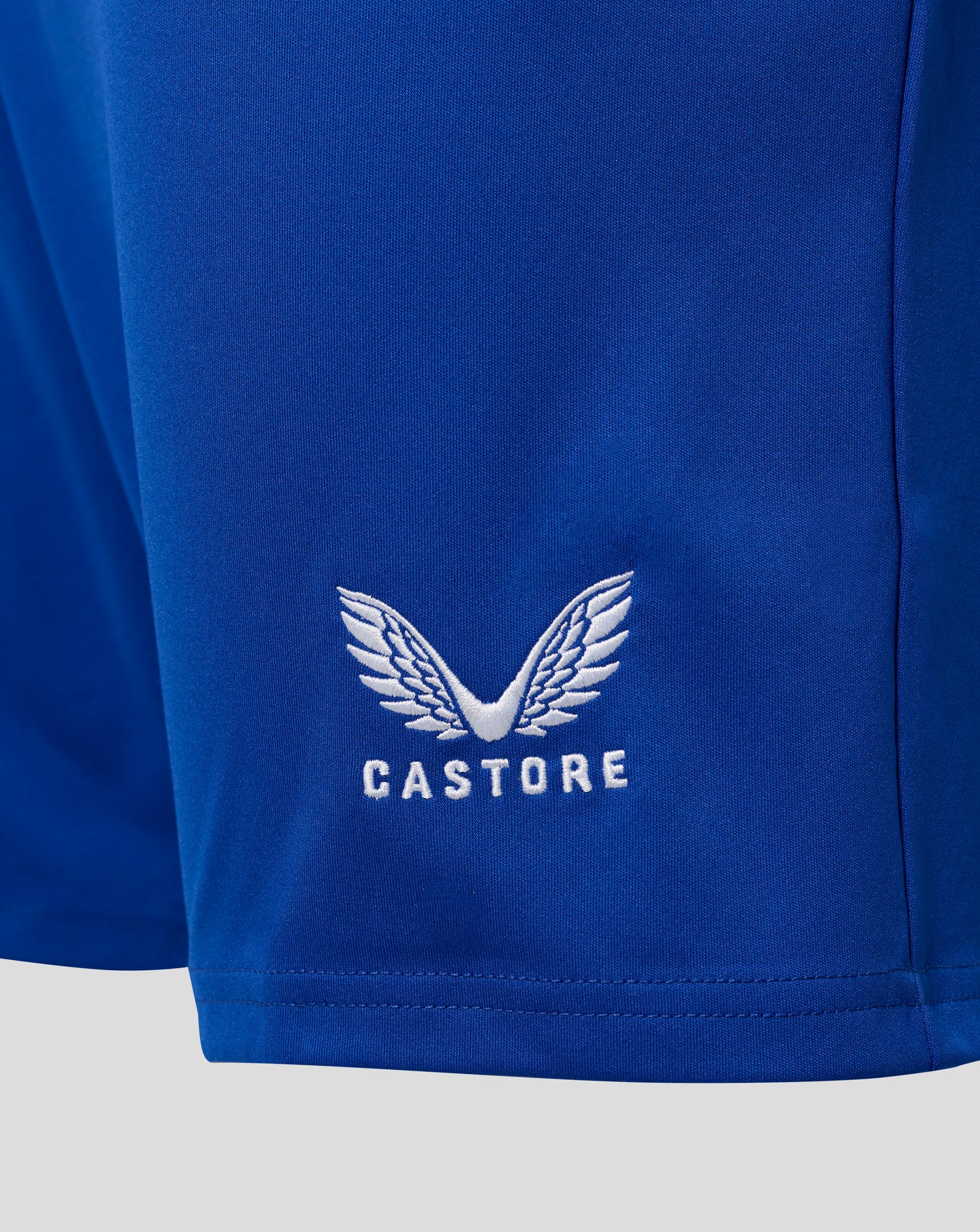 Close-up of blue Everton home shorts fabric showing white Castore crest embroidery