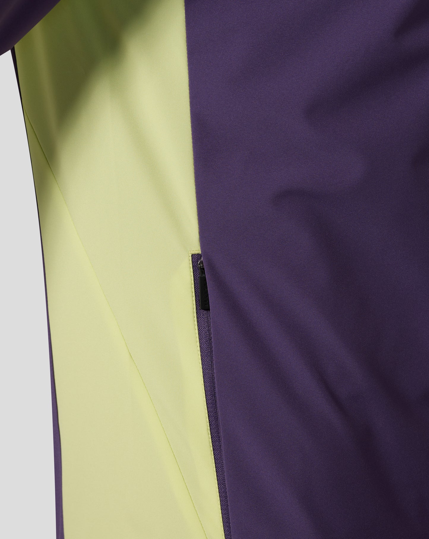 Close up of color blocked purple and lime packable hooded jacket with a zipper