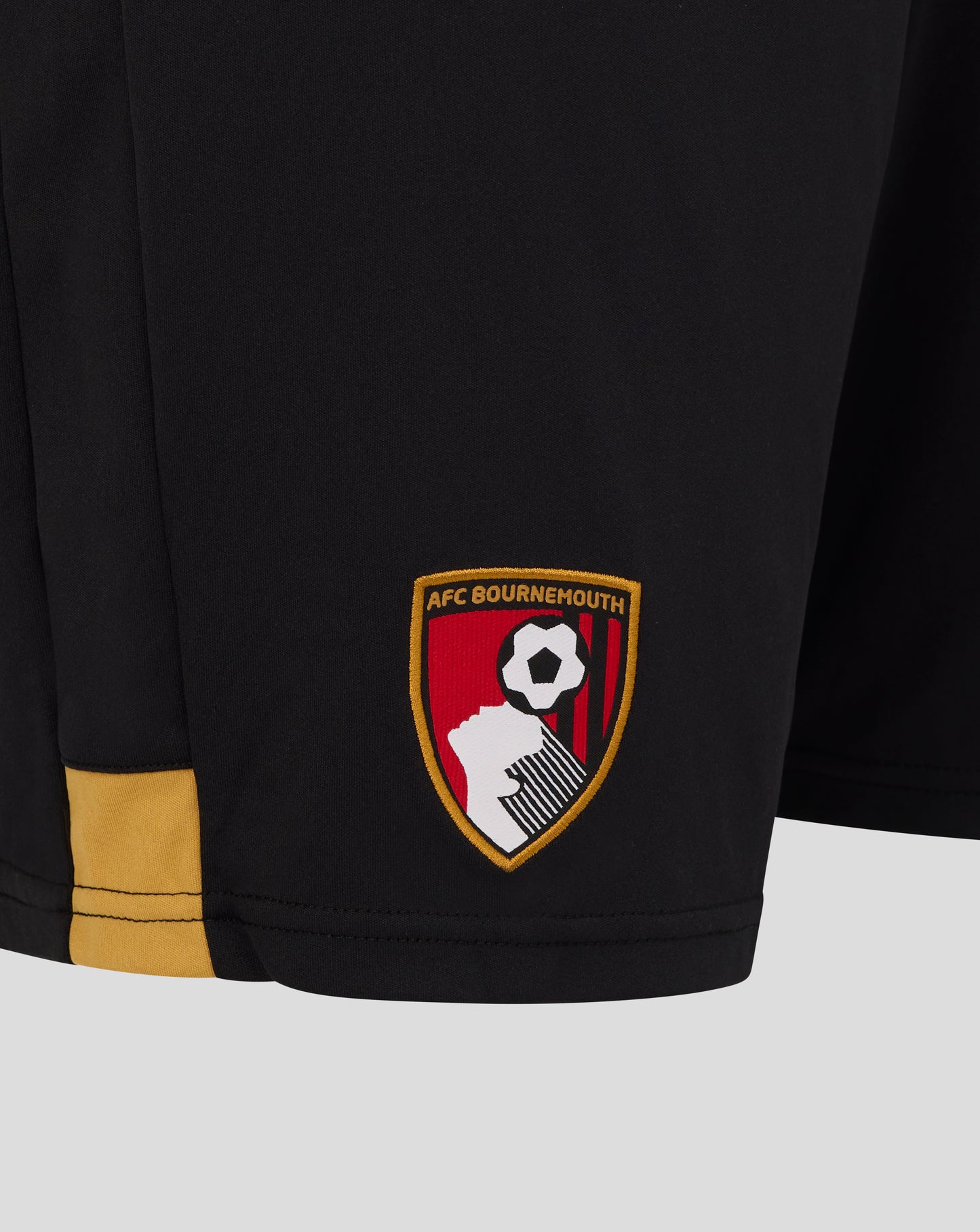 Close up of AFC Bournemouth crest on black shorts with yellow hem trim