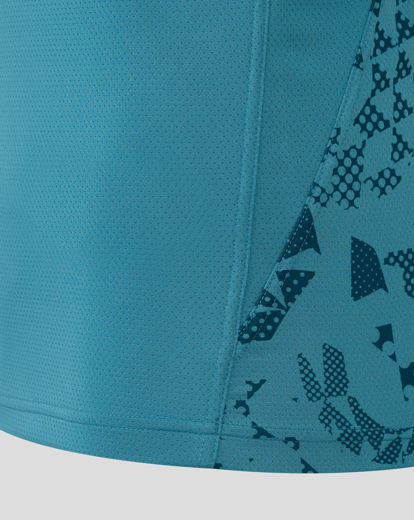 Close up of storm blue England Rugby performance fabric with a dotted mesh texture and diagonal patterned panel