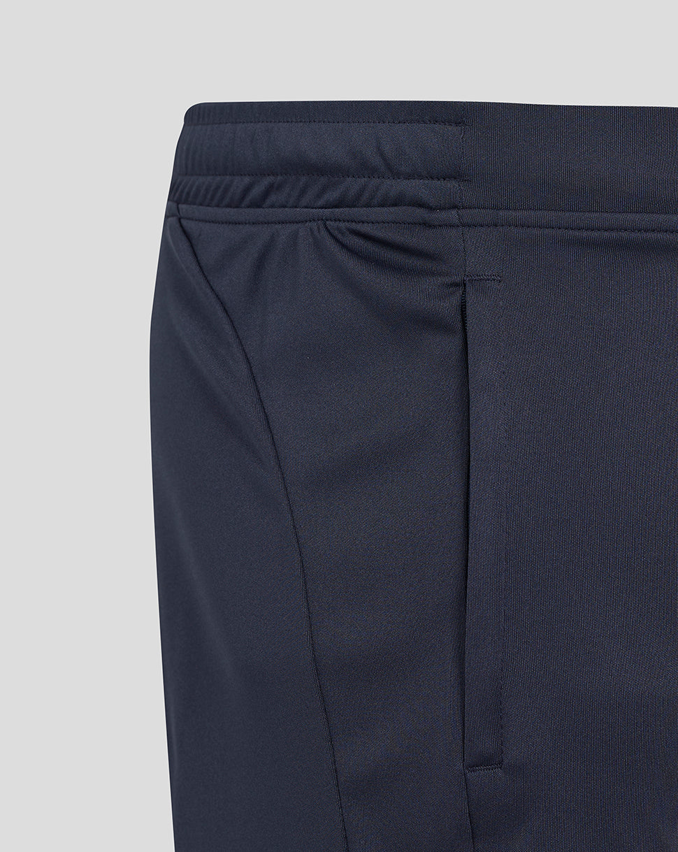 Detail of navy shorts featuring the elastic waistband and turquoise side panel with pocket seam.
