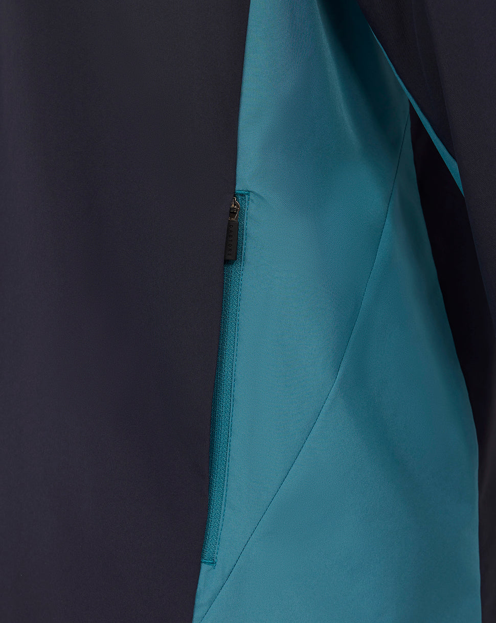 Navy shower jacket side with teal panel and zip pocket detail