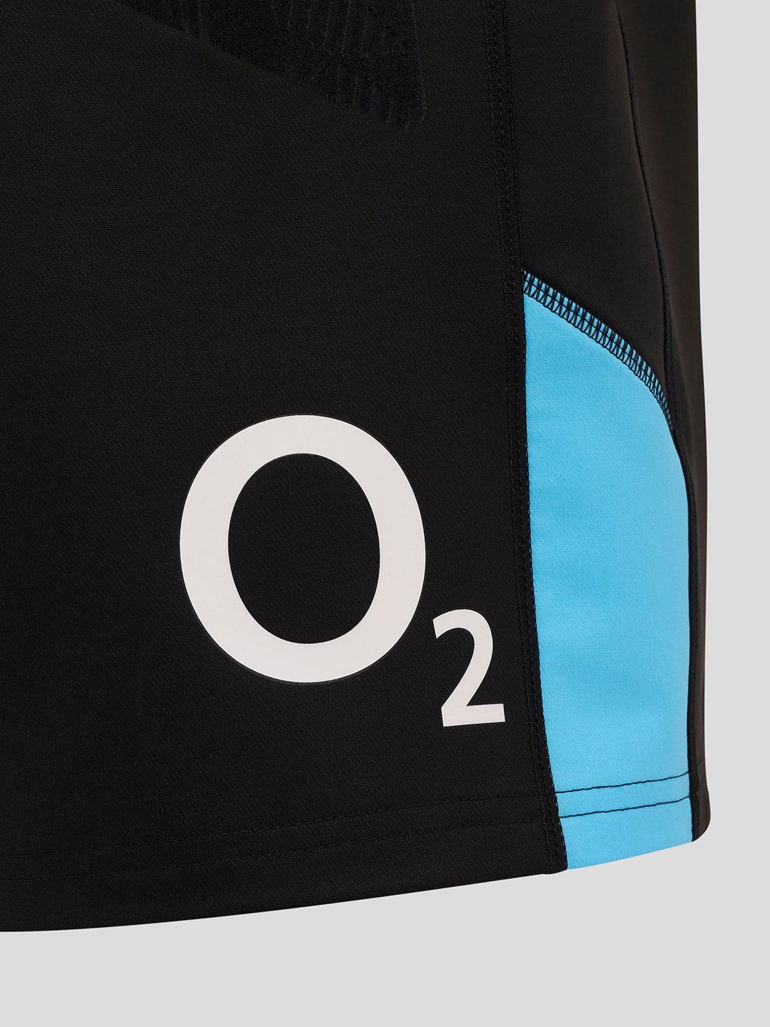 Close-up of black shorts side panel with bright blue accent and visible O2 logo