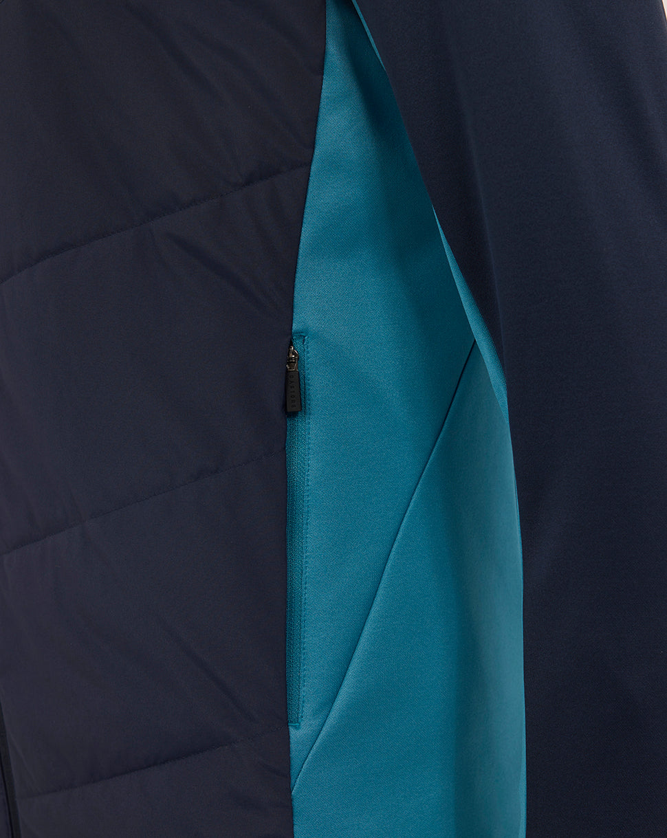 Close up of side seam on navy jacket showing teal contrasting panel and zip pocket
