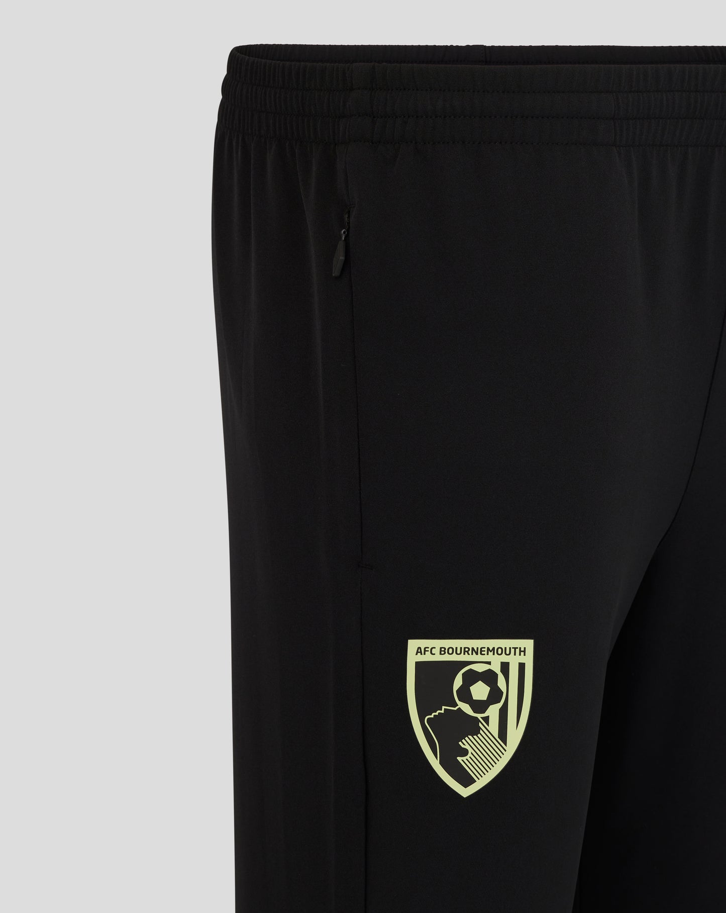 Close up of black athletic pants showing a zippered side pocket and an elastic waistband