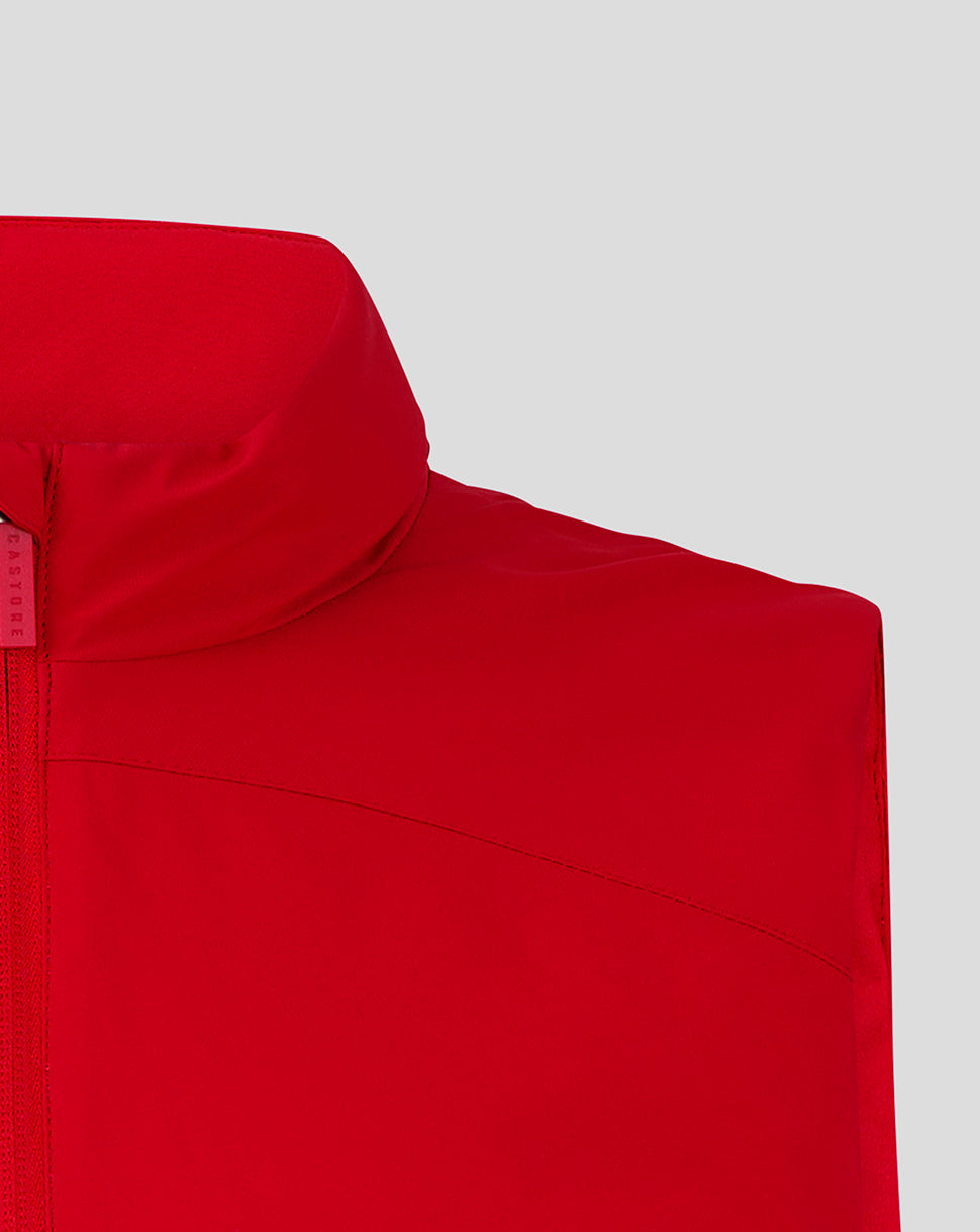 Close-up of red padded gilet shoulder and high collar with visible seam and zipper edge.