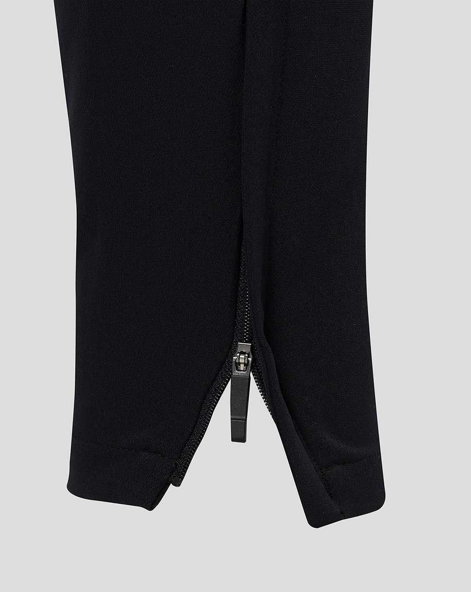 Close-up of the cuff on black men's track pants with a zipper at the ankle