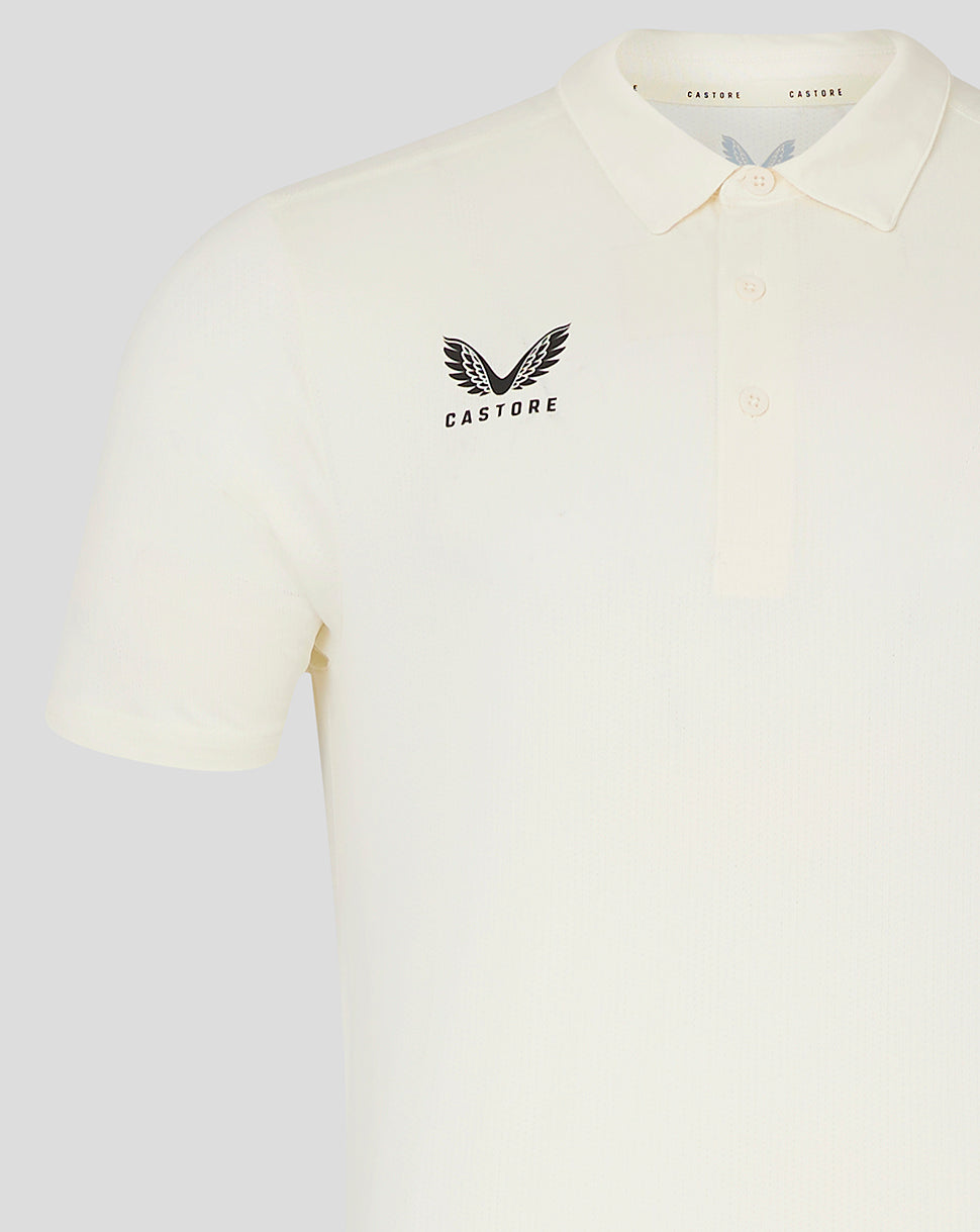 Front view of cream cricket polo showing Castore logo on the left chest and clean polo silhouette.