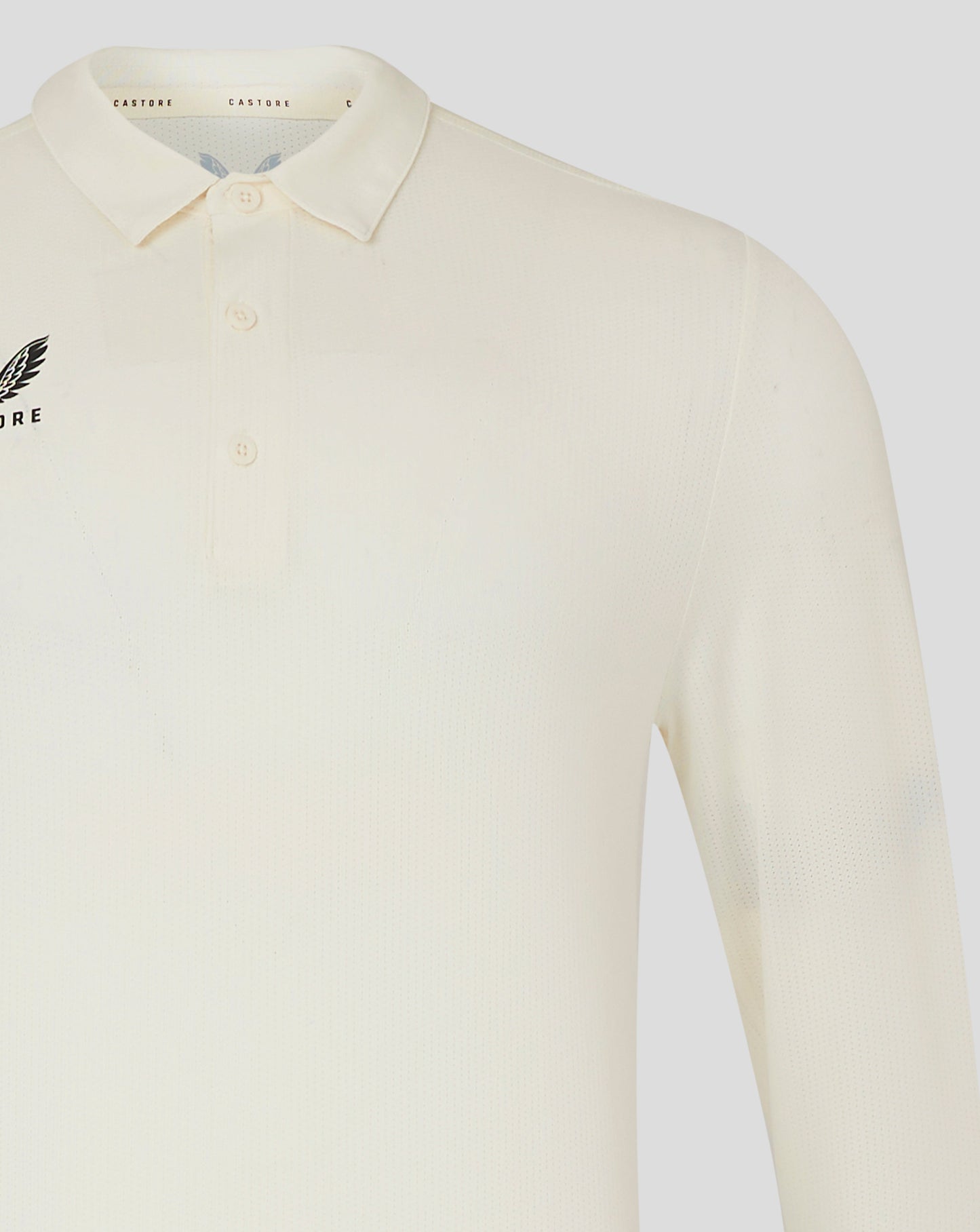 Front view of Cannoli Cream Castore cricket shirt with collar and small chest logo