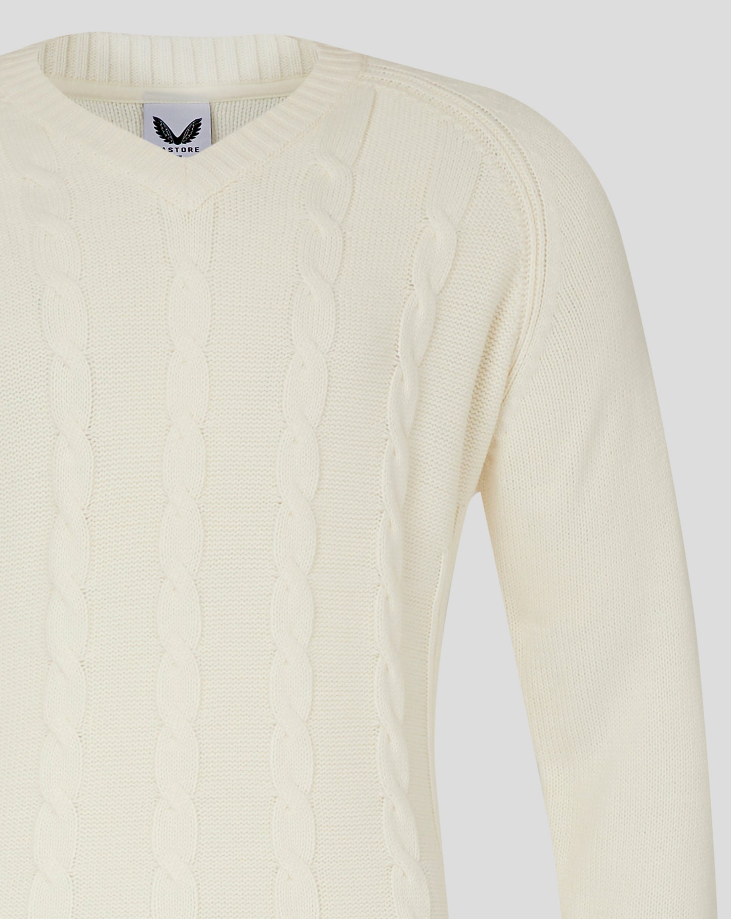 Front close up of Cannoli Cream cable knit jumper featuring V neck and cable pattern