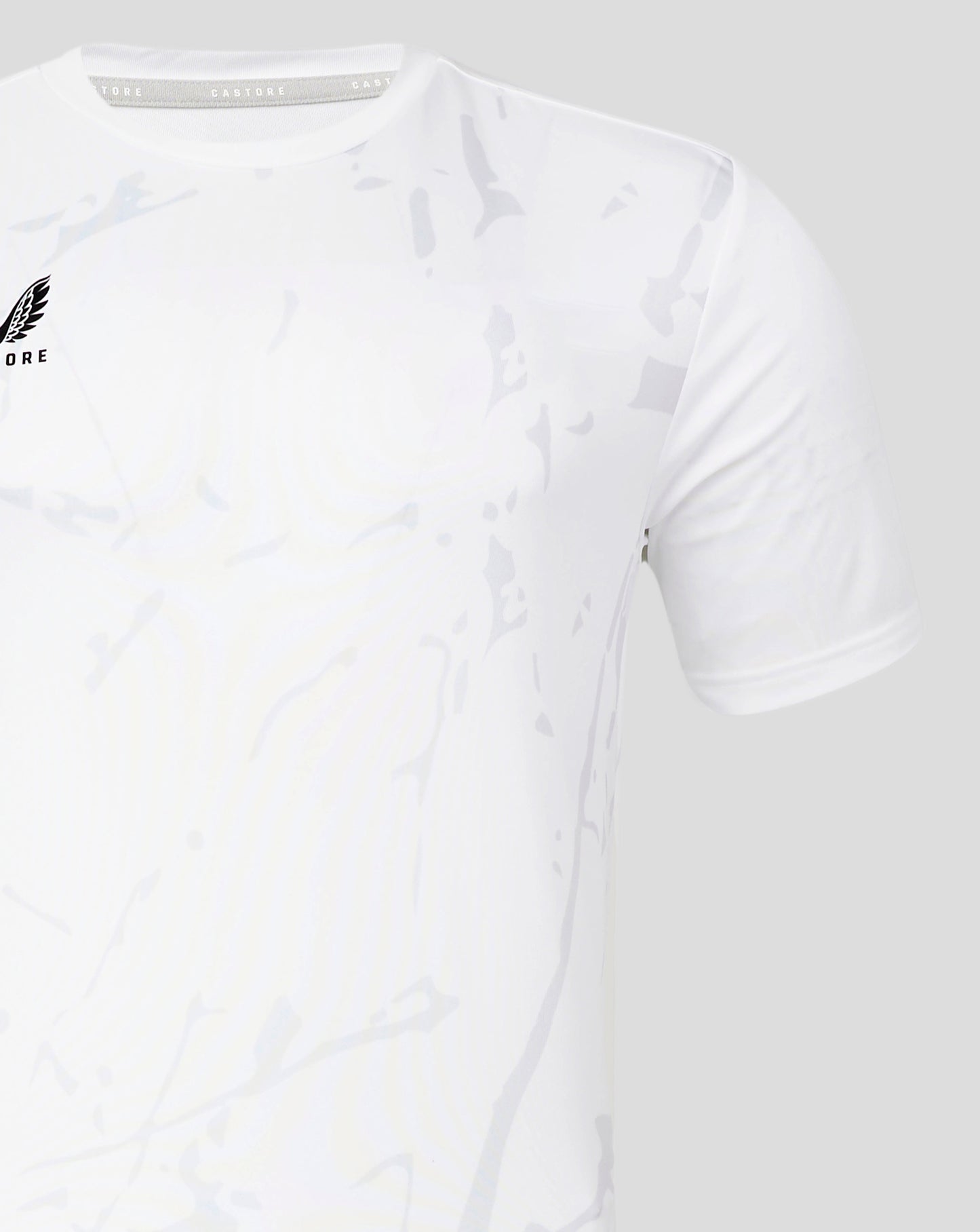 Front left chest Castore logo on a white Marble Performance Tee with a pale camouflage pattern