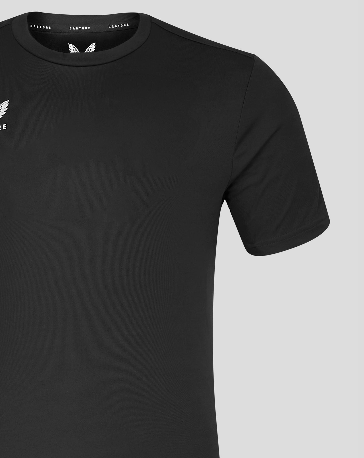 Black Castore performance tee close up at the neckline showing the left chest wing logo