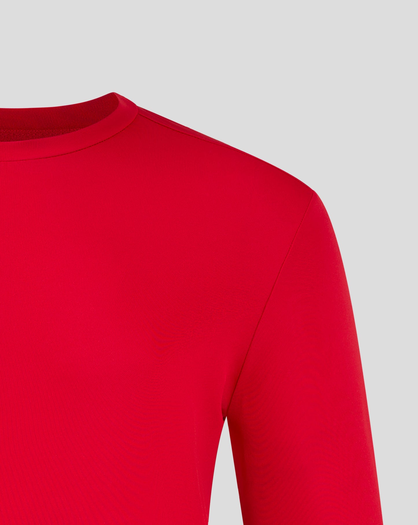 Close-up of a red long sleeve performance tee focusing on the crew neck and forward shoulder seam with Castore branding