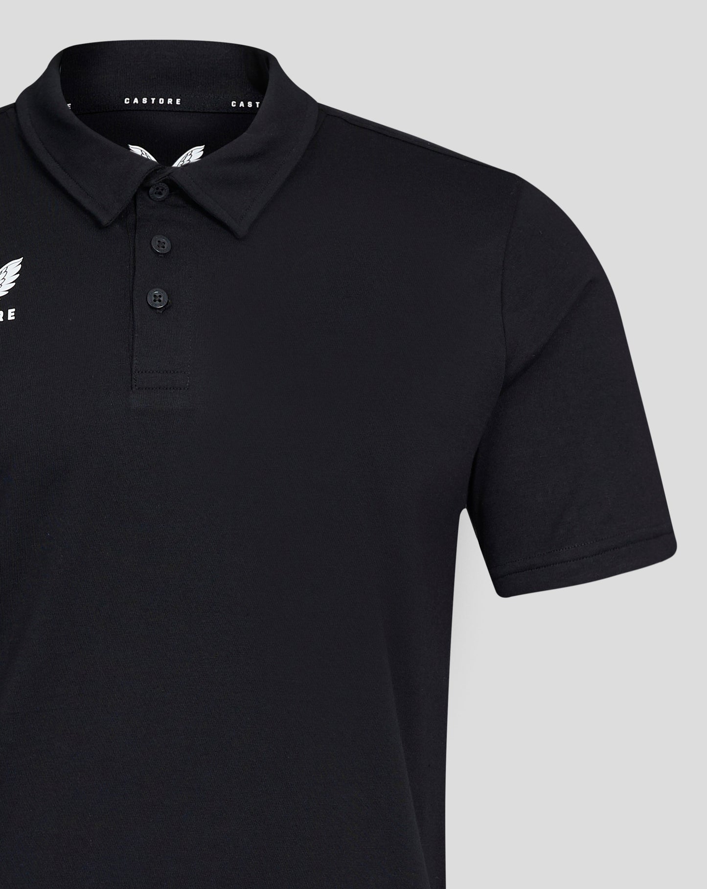 Close up of black Mens Cotton Leisure Polo with self fabric collar three button placket and white Castore logo on chest.