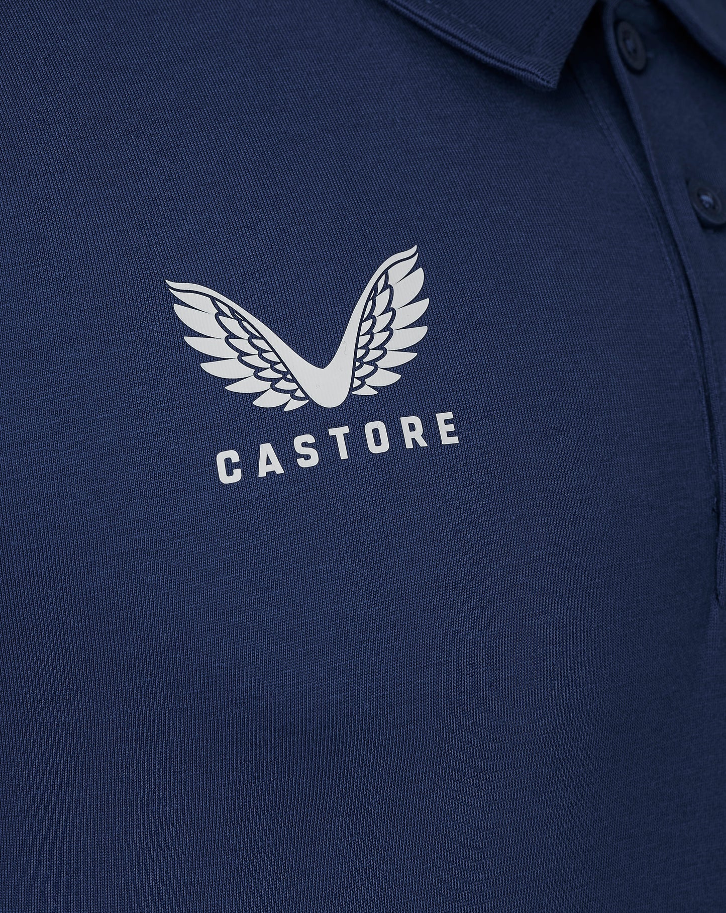 Navy cotton leisure polo shirt close up with a white Castore wing logo on the chest and a visible collar.