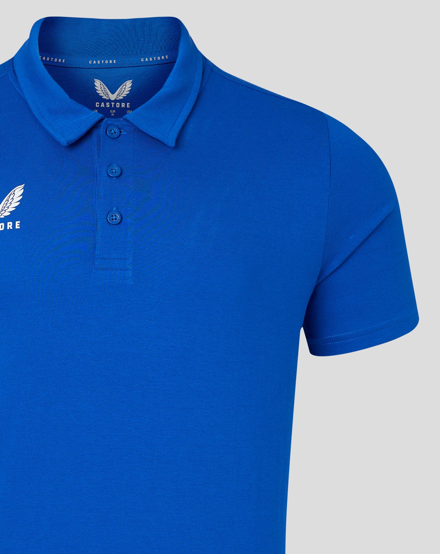 Bright blue polo featuring a three button placket and Castore logo on the left chest