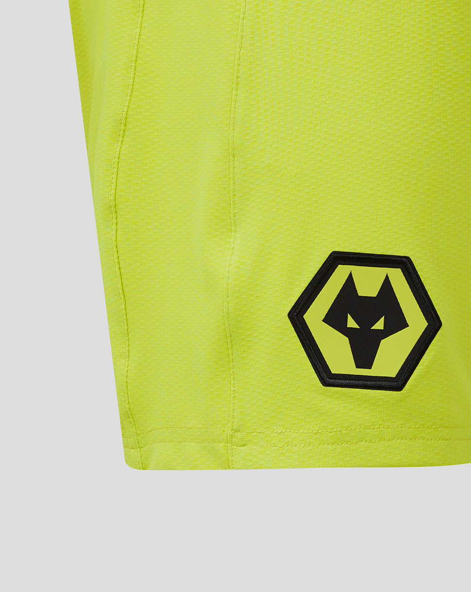 Close up of neon lime shorts showing a black wolf head inside a hexagonal logo on the leg.