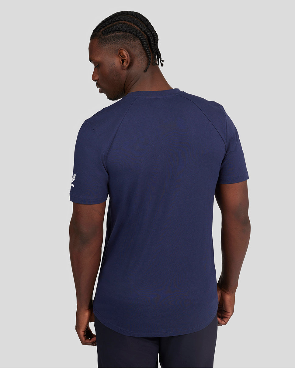 Back view of a man wearing a navy Ocean Cavern Le Mans lifestyle T shirt with a curved hem