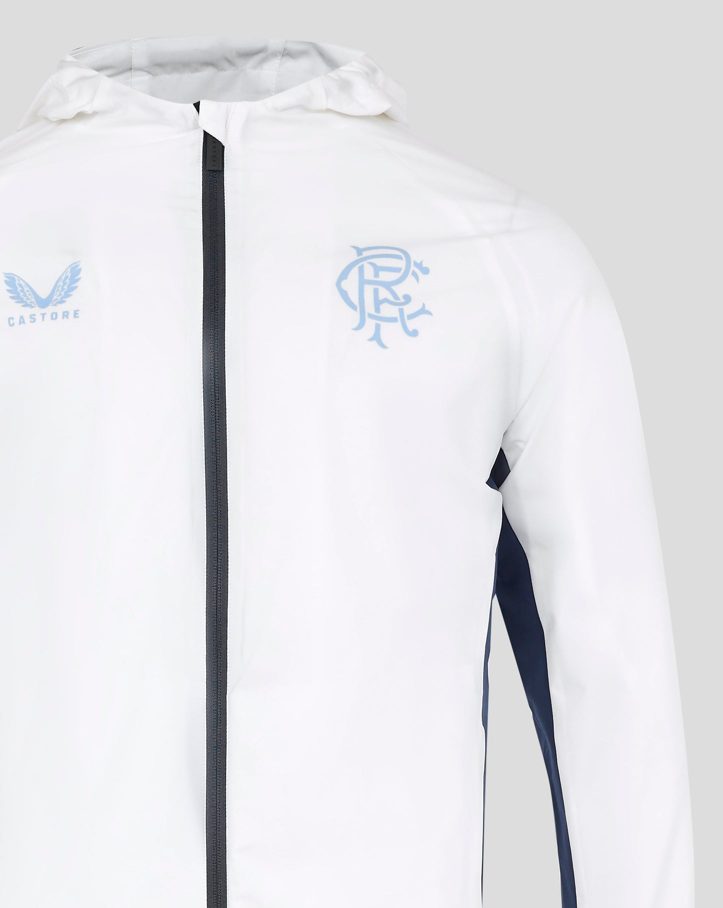 Close up of white rain jacket chest with zipper center and light blue crest on the right with a navy side panel