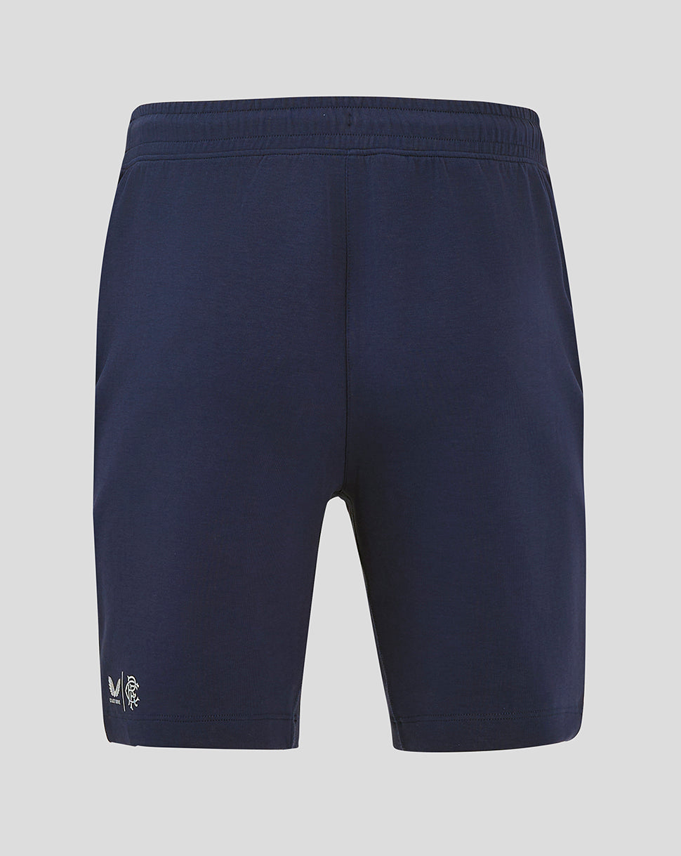 Back view of navy Rangers FC travel shorts with elastic waistband and small white club logo near the hem.