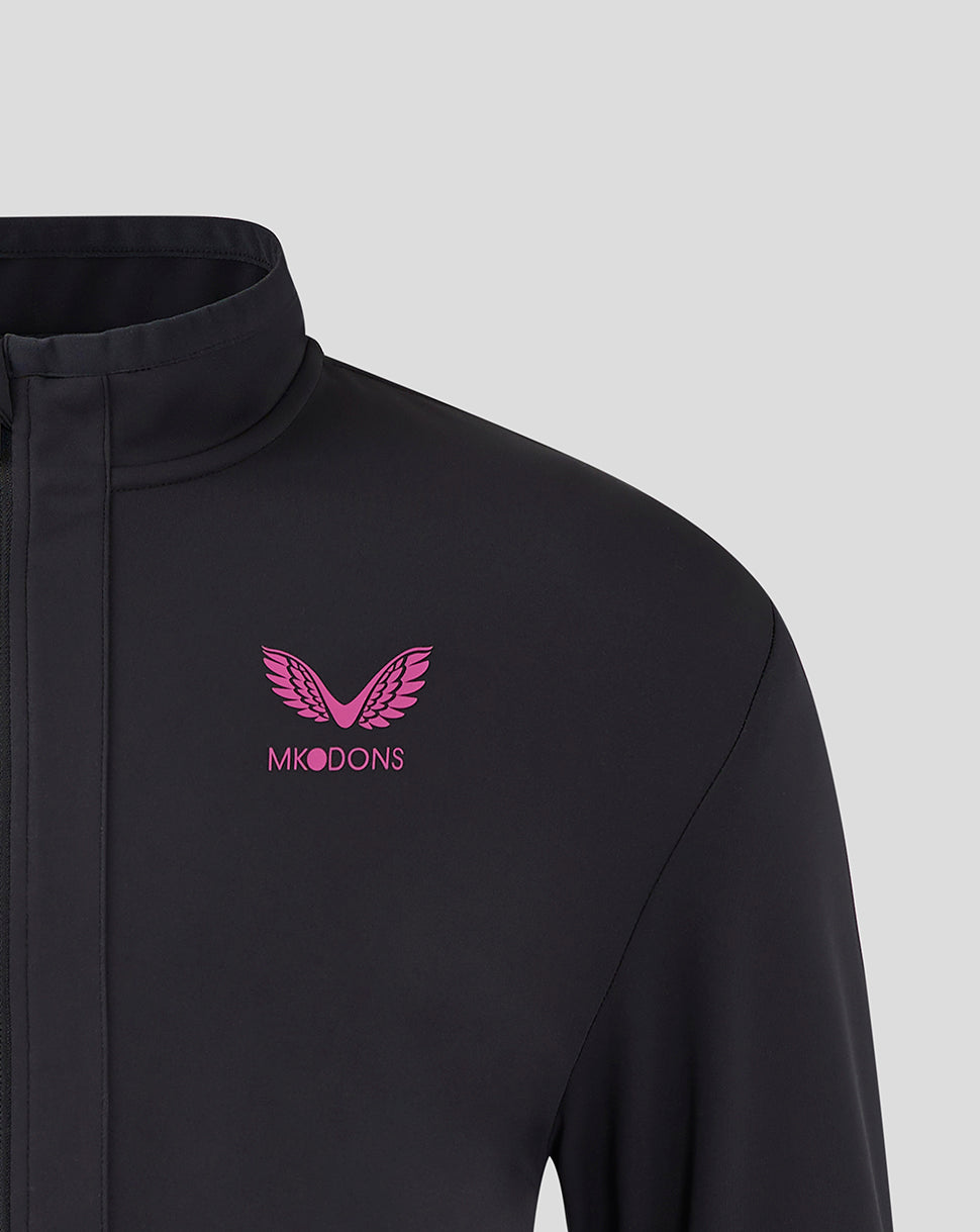 Front left chest of black Mk Dons travel jacket with pink logo emblem