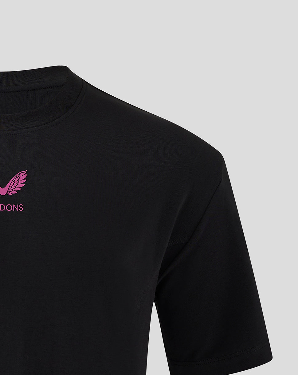 Close up of the upper chest on a black Mk Dons Travel T Shirt with pink logo and MK DONS lettering