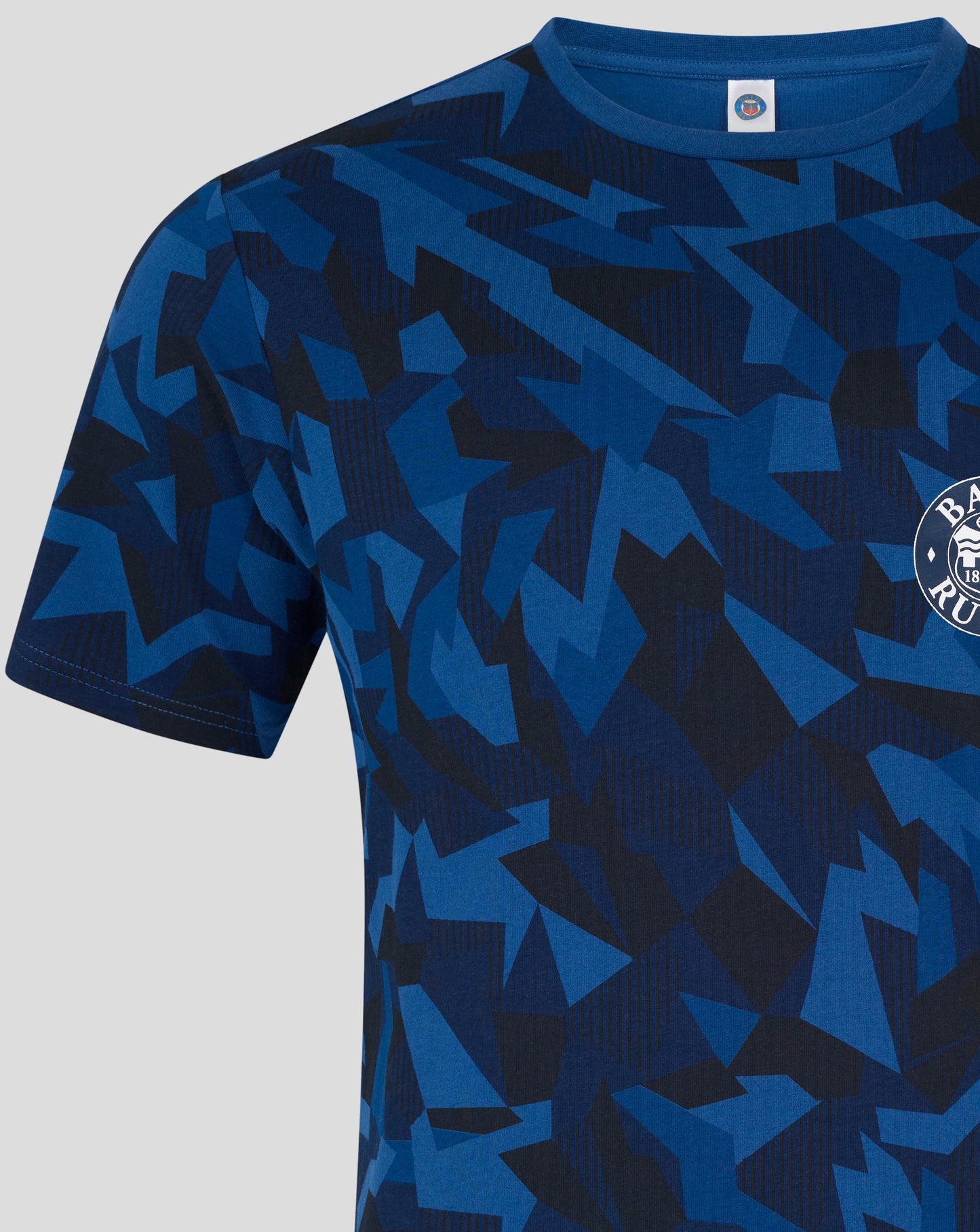 Close up of Bath Rugby top in blue geometric print with a crest visible at the lower right