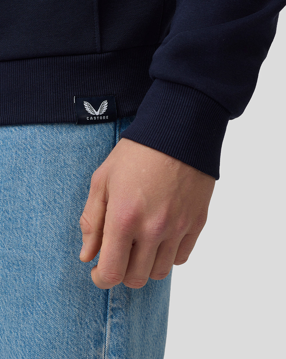 Close up of navy hoodie cuff with a Castore label and jeans in view