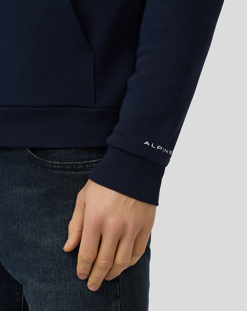 Close up of a navy Core Essentials Hoodie sleeve displaying the Alpine logo at the cuff