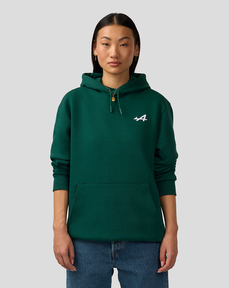 Front view of a woman wearing a green Alpine hoodie with a small logo on the chest and drawstring hood.