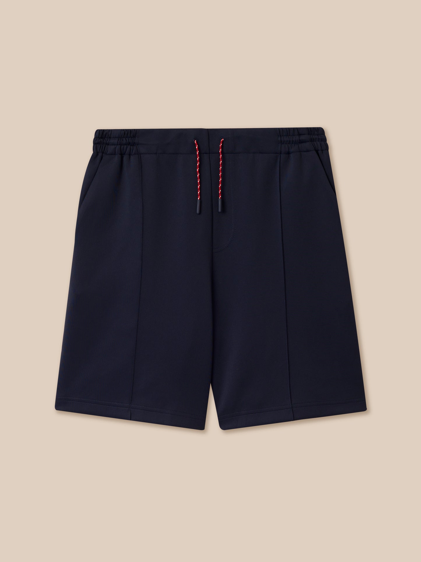 Close-up of navy shorts waist showing flat front waistband with elastic at back and three colored knit drawcords