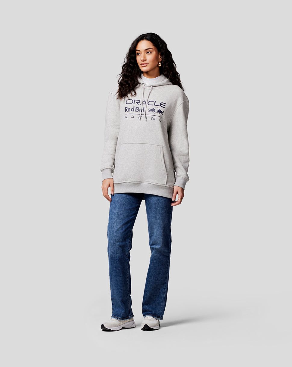 Female model in grey marl Oracle Red Bull Racing hoodie with large logo, paired with jeans and sneakers