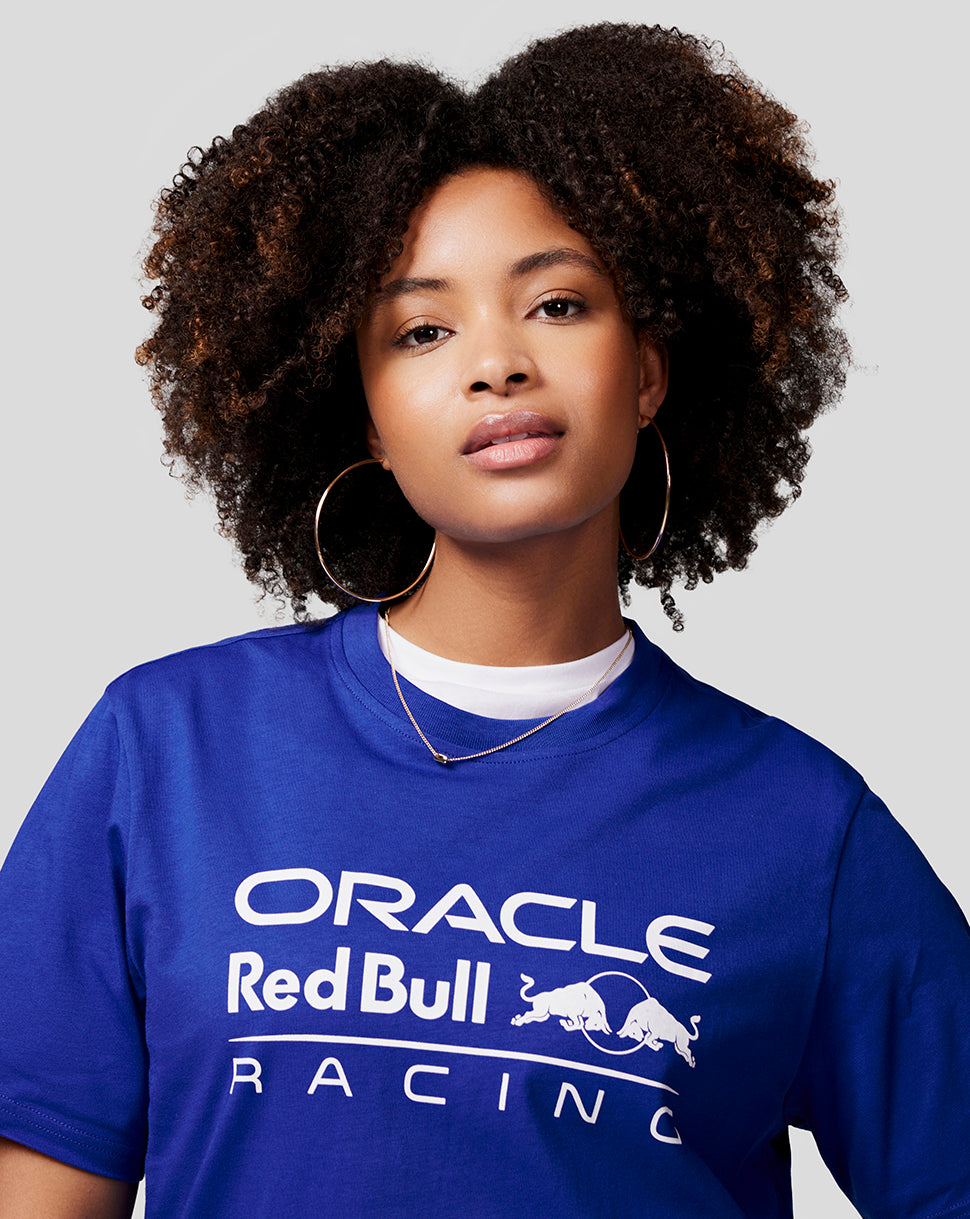 Close-up of a woman in a blue Oracle Red Bull Racing tee showing the large white logo on the chest