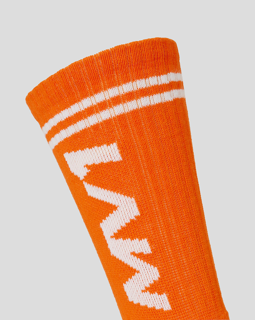 Close up of Exotic Orange driver sock showing bold MV logo and white cuff stripes
