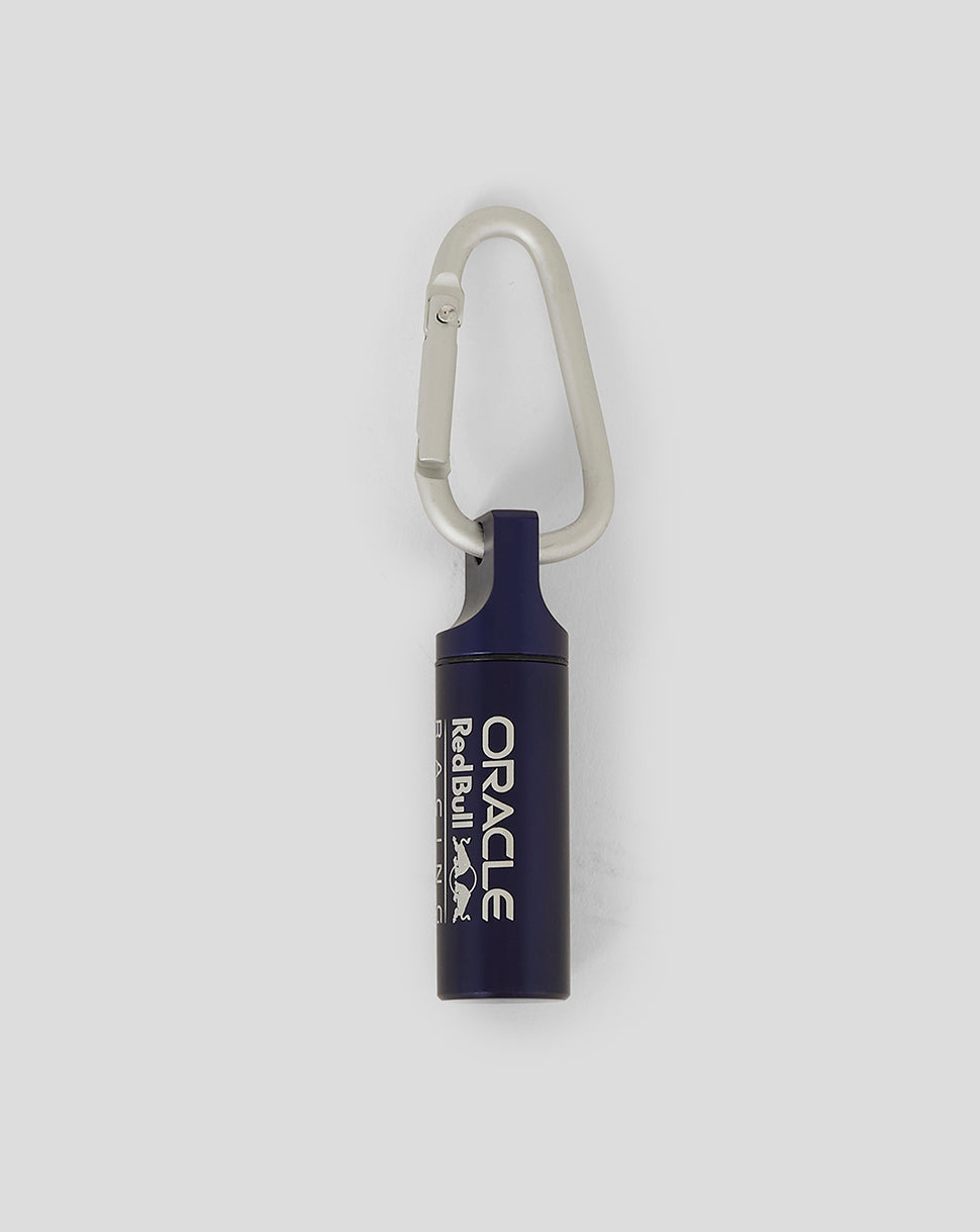Close-up of Oracle Red Bull Racing ear plug canister keyring in night sky with white branding and carabiner