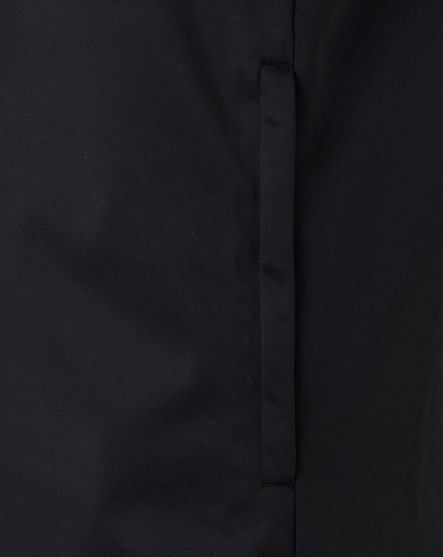 Close-up of black fabric showing front zip and seam detail on the softshell gilet.