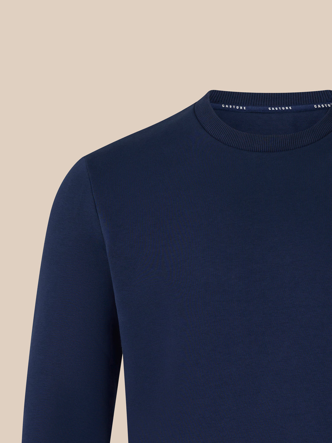 Navy crewneck sweatshirt close up of neck area with ribbed collar and left chest logo.