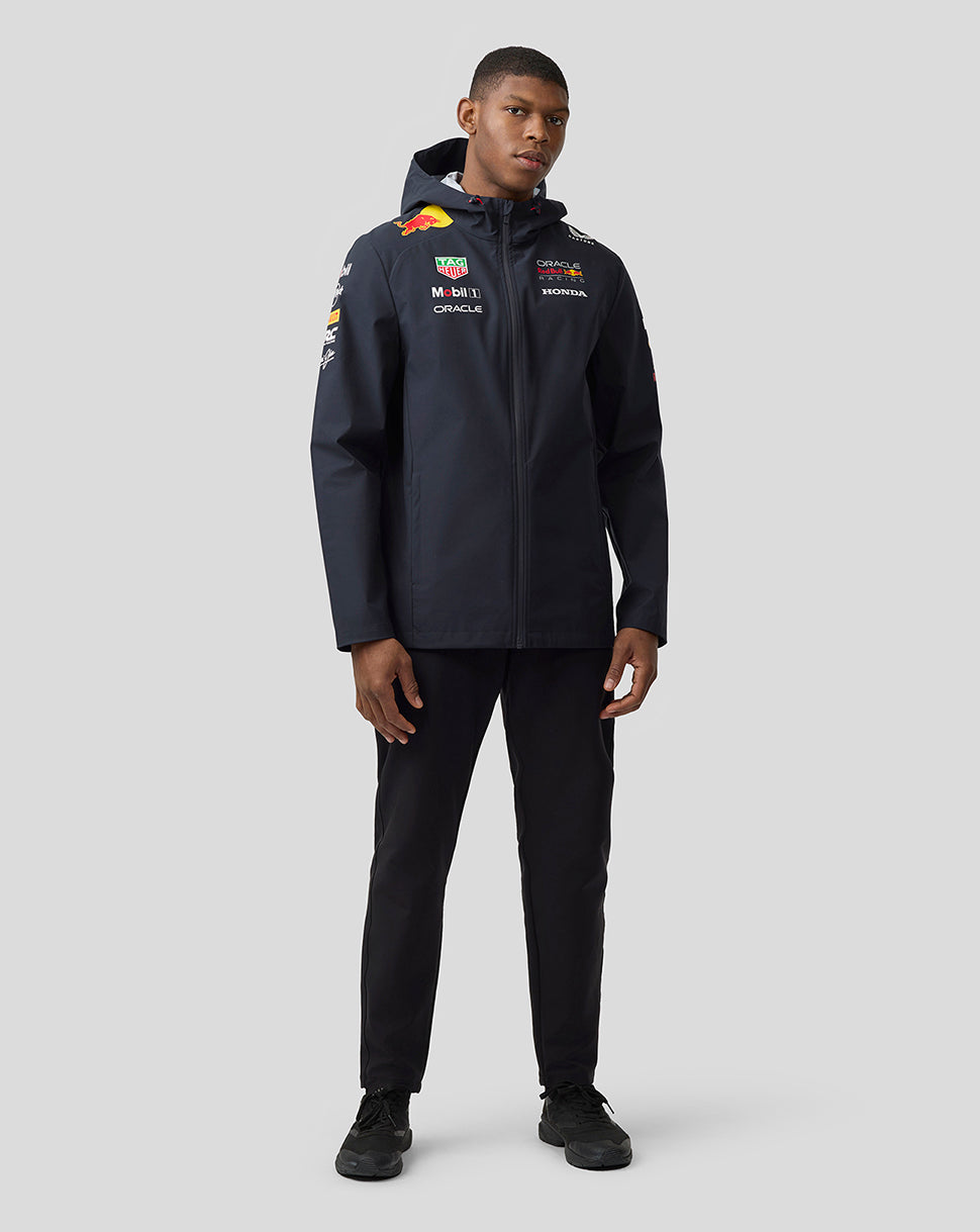 Full-body front view of a male model wearing the navy Oracle Red Bull Racing Teamline jacket with logos