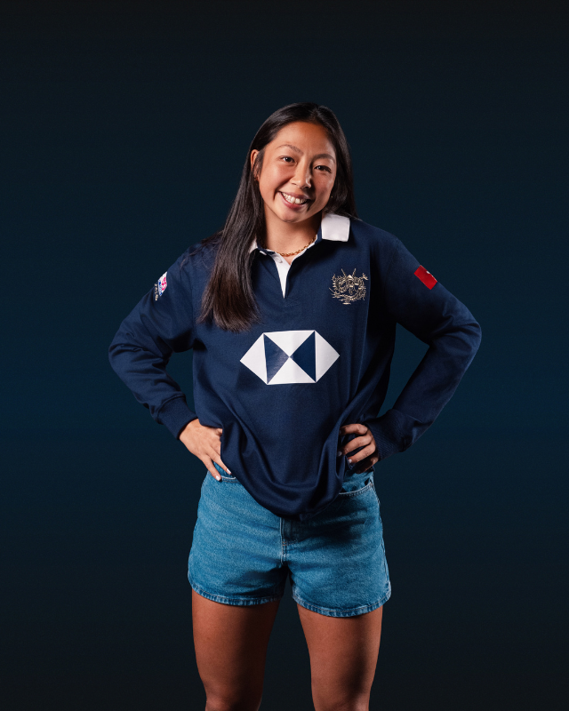 Female model wearing a vintage navy long sleeve HK7s rugby jersey with crest and white geometric chest logo.