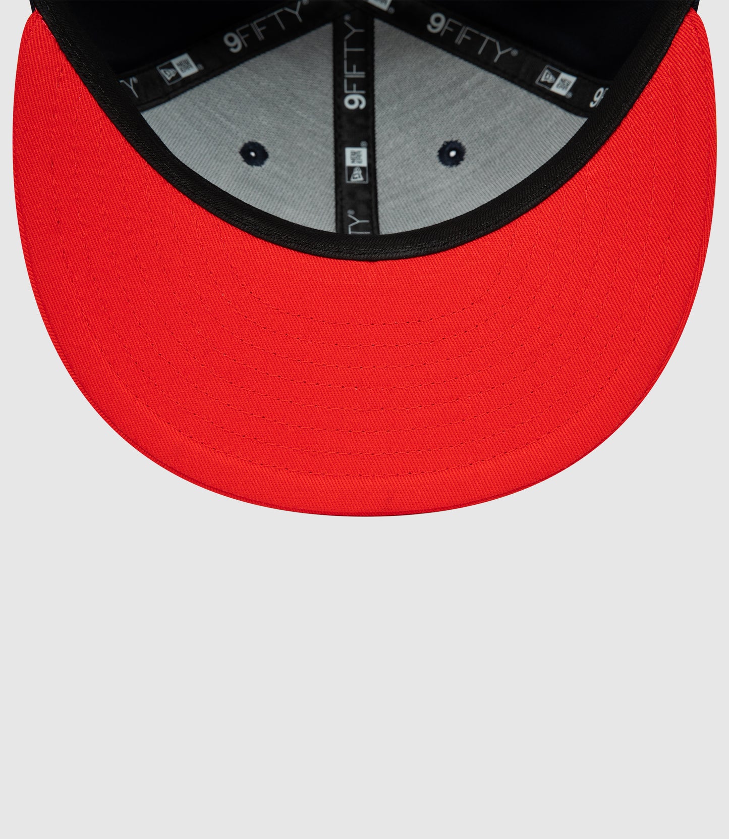 Close up of red brim on navy cap showing interior 9FIFTY branding