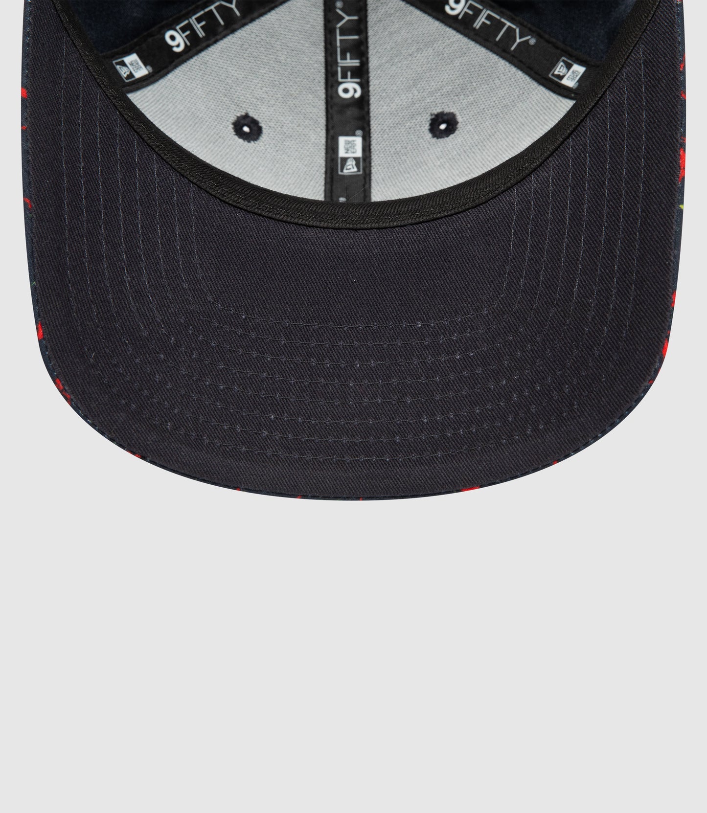 Interior view of navy New Era 9FIFTY snapback showing branded tape and adjustable rear strap